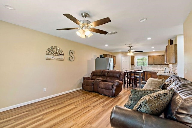 living room with ceiling fan and light hardwood / wood-style floors