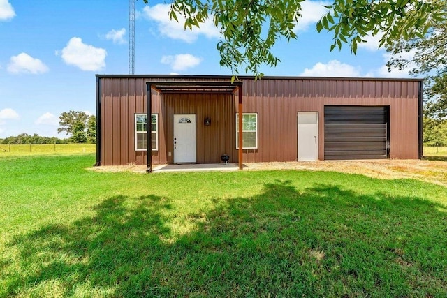 view of outdoor structure featuring a garage and a lawn