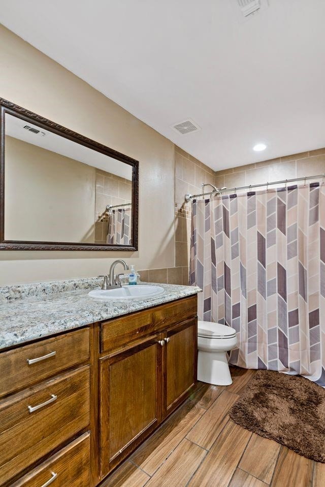 bathroom with vanity, toilet, and hardwood / wood-style floors