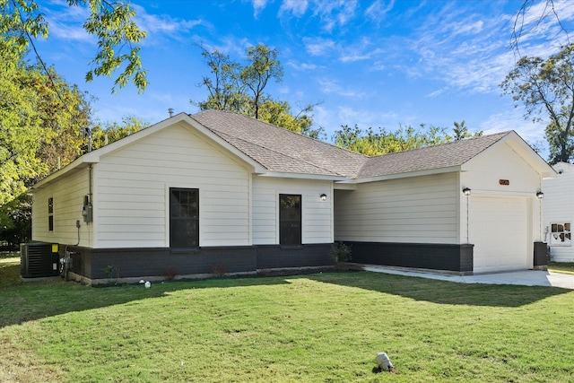 ranch-style home featuring central AC unit, a garage, and a front yard