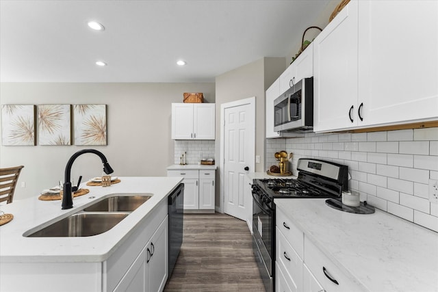 kitchen featuring light stone counters, stainless steel appliances, sink, and white cabinets