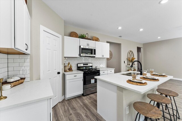 kitchen with white cabinets, a breakfast bar, sink, and appliances with stainless steel finishes