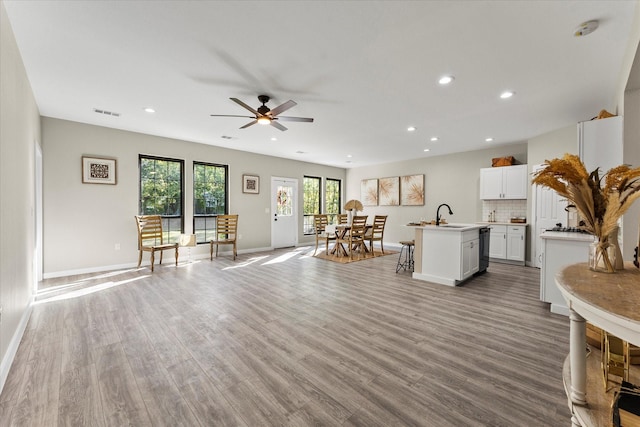 living room with ceiling fan, sink, and light hardwood / wood-style floors