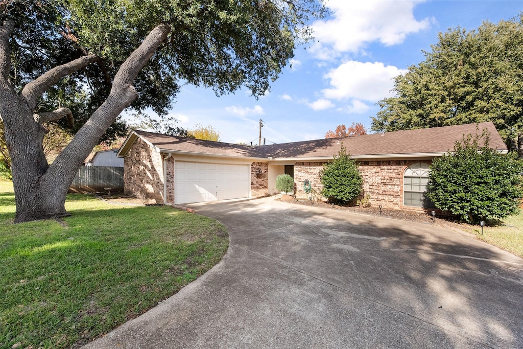 ranch-style house featuring a garage and a front yard