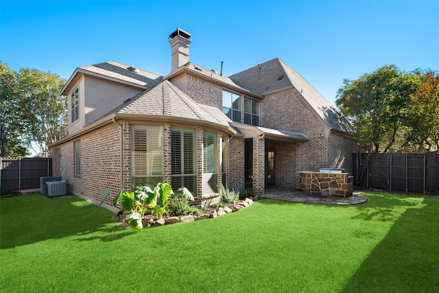 rear view of house with cooling unit, a patio area, and a lawn