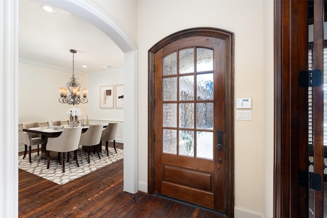 entryway featuring ornamental molding, dark wood-type flooring, a chandelier, and a healthy amount of sunlight