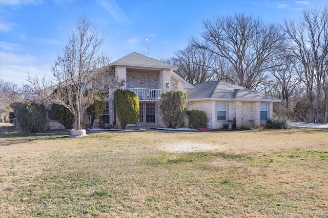 view of front facade with a front yard and a balcony