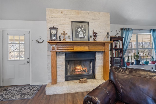 living room with a fireplace, a healthy amount of sunlight, and dark hardwood / wood-style flooring