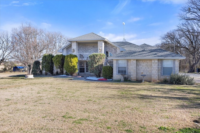 view of front of property featuring a balcony and a front lawn