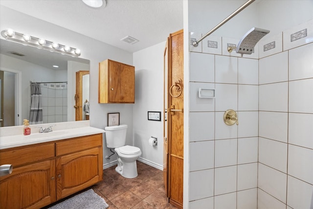 bathroom featuring walk in shower, vanity, toilet, and tile patterned flooring