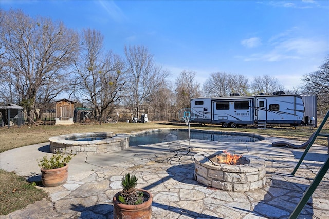 view of pool with a patio, a storage unit, and a fire pit