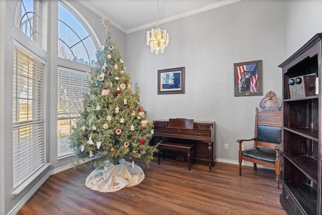 sitting room with ornamental molding, dark wood-type flooring, a wealth of natural light, and a notable chandelier