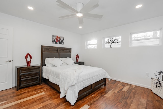 bedroom with recessed lighting, wood finished floors, and baseboards