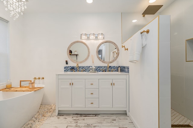 bathroom with a sink, a freestanding bath, double vanity, and a walk in shower