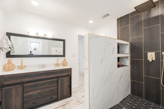 bathroom with a sink, visible vents, walk in shower, and double vanity