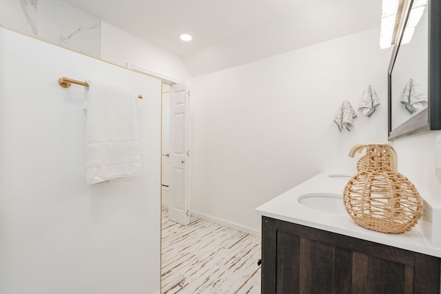 bathroom featuring double vanity, recessed lighting, wood finished floors, and baseboards