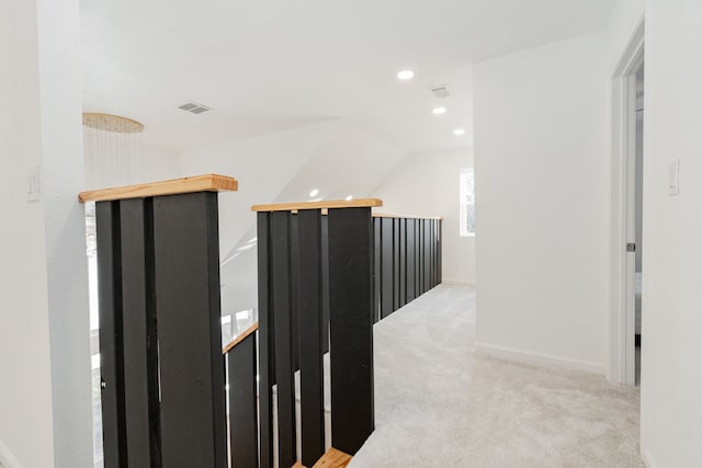 hallway featuring visible vents, lofted ceiling, recessed lighting, an upstairs landing, and light colored carpet