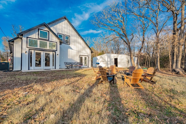 back of property with french doors, board and batten siding, and central AC