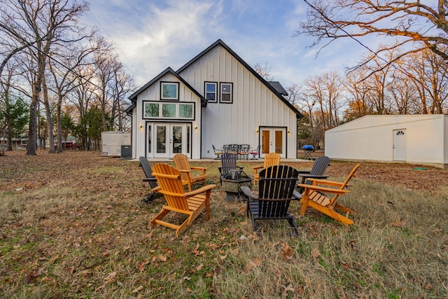 back of property featuring french doors, an outdoor fire pit, and board and batten siding