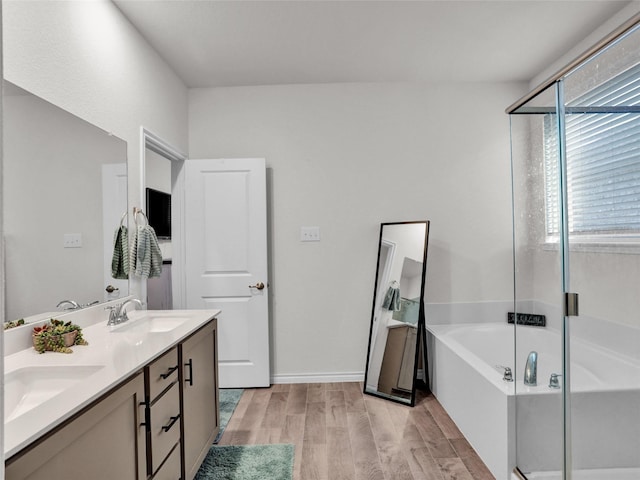 bathroom with hardwood / wood-style flooring, vanity, and shower with separate bathtub