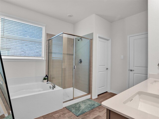 bathroom with plus walk in shower, vanity, and hardwood / wood-style flooring