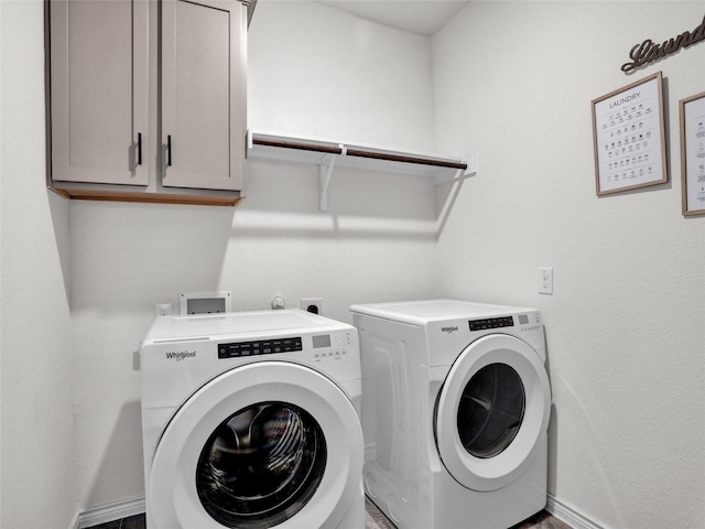 laundry area featuring washer and dryer and cabinets