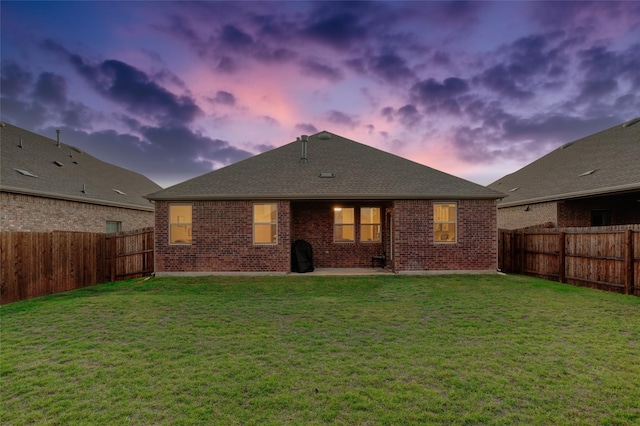 back house at dusk with a yard