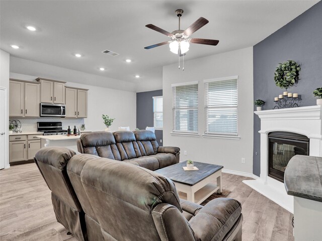 living room featuring ceiling fan and light hardwood / wood-style floors