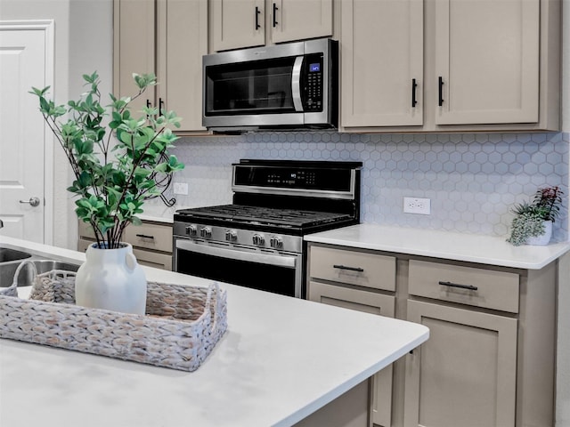 kitchen with gray cabinetry, stainless steel appliances, and tasteful backsplash