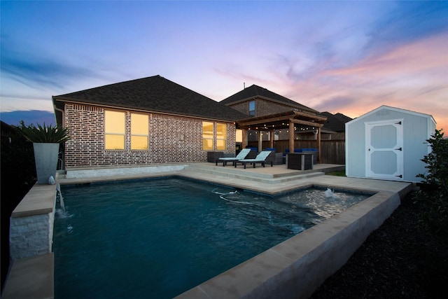 pool at dusk featuring pool water feature, a patio, and a storage shed