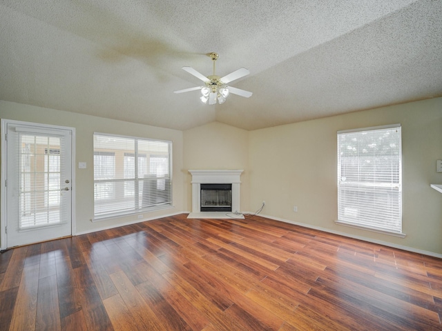 unfurnished living room featuring a textured ceiling, dark hardwood / wood-style floors, ceiling fan, and lofted ceiling