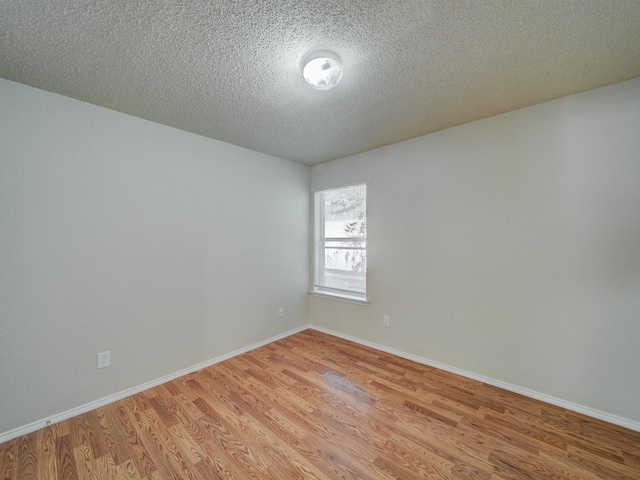 unfurnished room with a textured ceiling and light hardwood / wood-style flooring