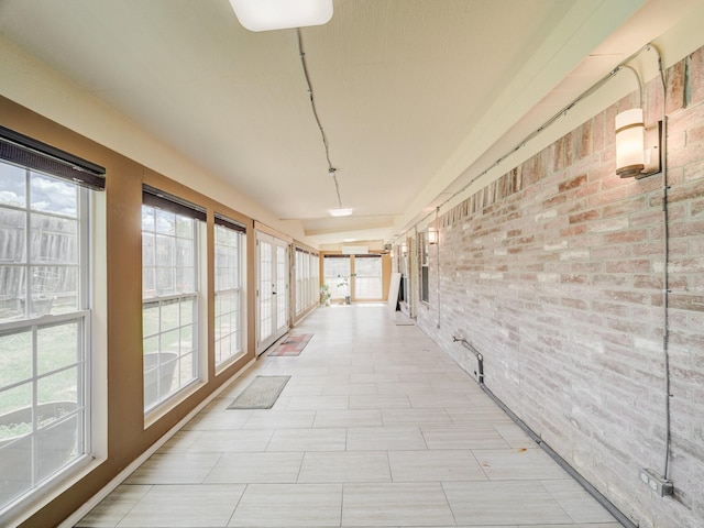 hallway featuring a wealth of natural light and brick wall