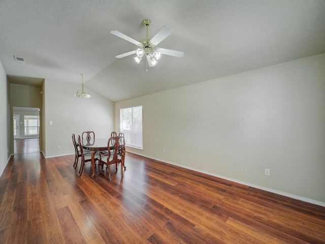 dining area with lofted ceiling, dark hardwood / wood-style floors, ceiling fan with notable chandelier, and a textured ceiling