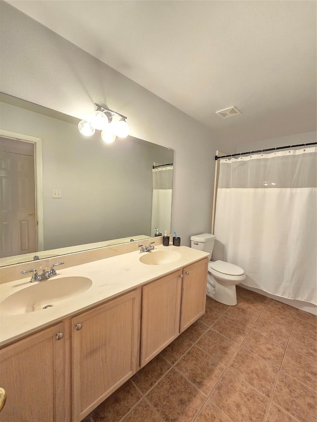 bathroom with tile patterned flooring, vanity, and toilet