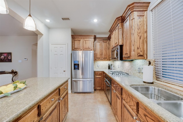 kitchen featuring appliances with stainless steel finishes, backsplash, sink, light tile patterned floors, and pendant lighting