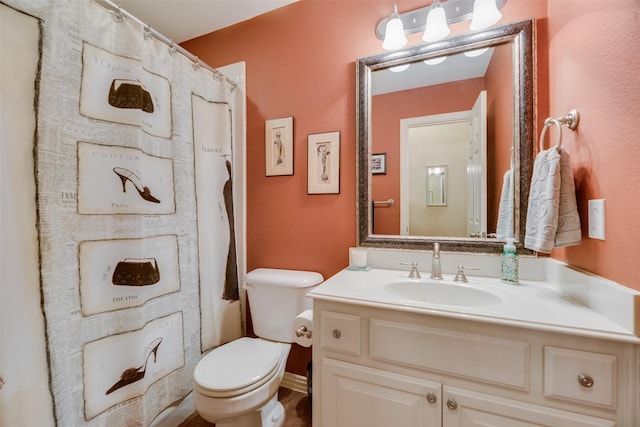 bathroom featuring a shower with shower curtain, vanity, and toilet