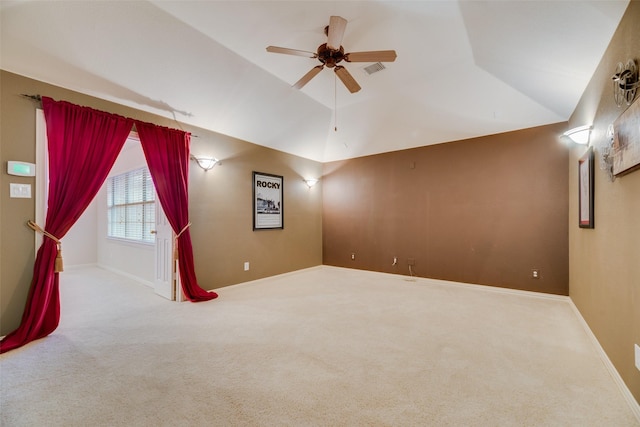 carpeted spare room with ceiling fan and vaulted ceiling