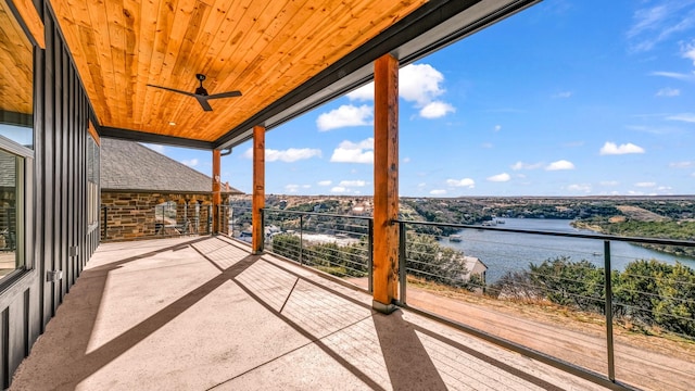 balcony with ceiling fan and a water view