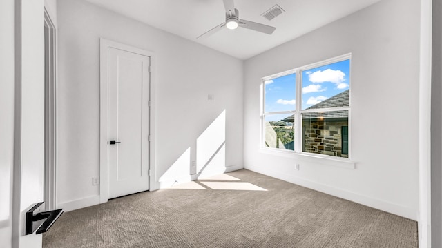 empty room with ceiling fan and light colored carpet