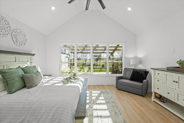 bedroom featuring ceiling fan, light hardwood / wood-style flooring, and high vaulted ceiling