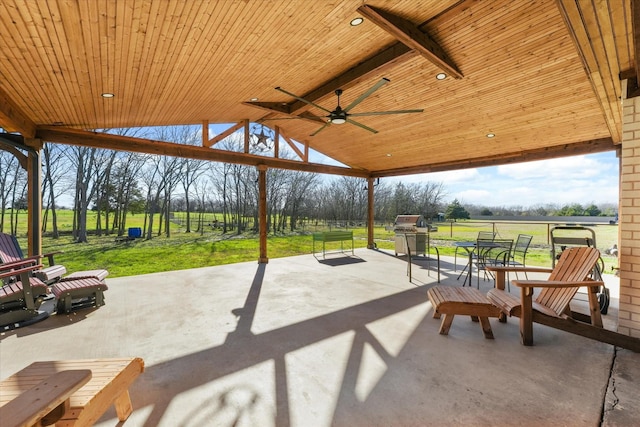 view of patio featuring ceiling fan, area for grilling, and a rural view