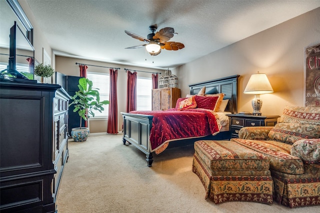 bedroom featuring a textured ceiling, carpet flooring, and a ceiling fan