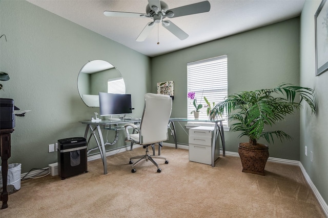 home office with baseboards, a ceiling fan, and light colored carpet