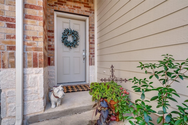 property entrance featuring brick siding