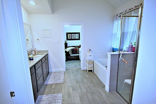 bathroom with hardwood / wood-style floors, vanity, and plus walk in shower