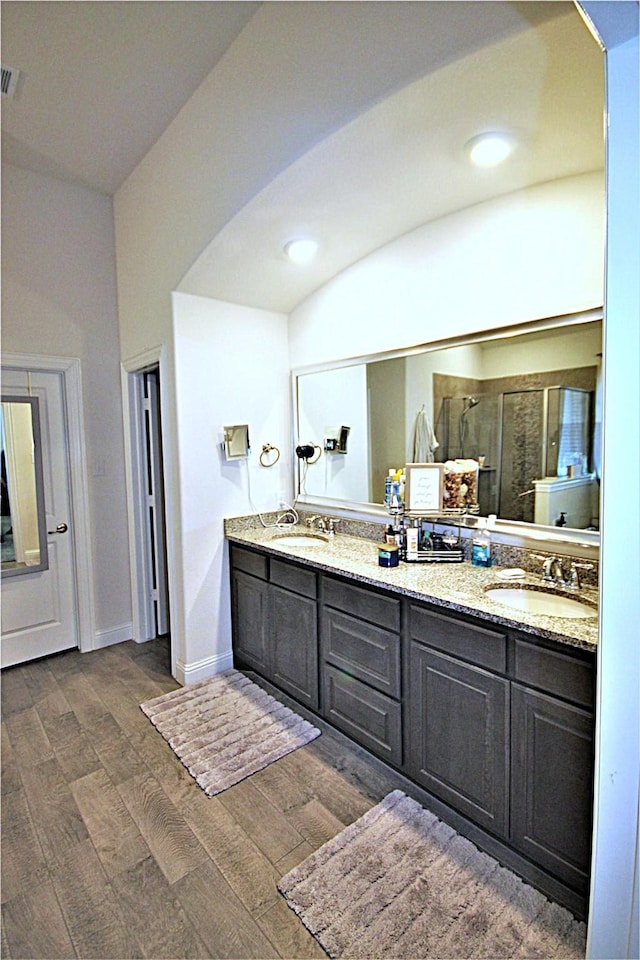 bathroom featuring hardwood / wood-style flooring, vanity, and an enclosed shower