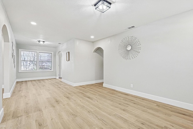 spare room with light hardwood / wood-style flooring and a textured ceiling