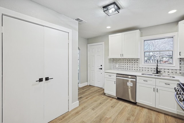 kitchen with white cabinetry, stainless steel appliances, sink, and tasteful backsplash