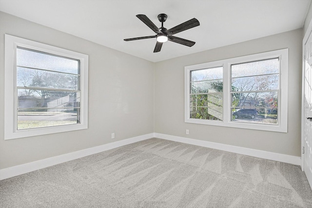 carpeted spare room featuring ceiling fan